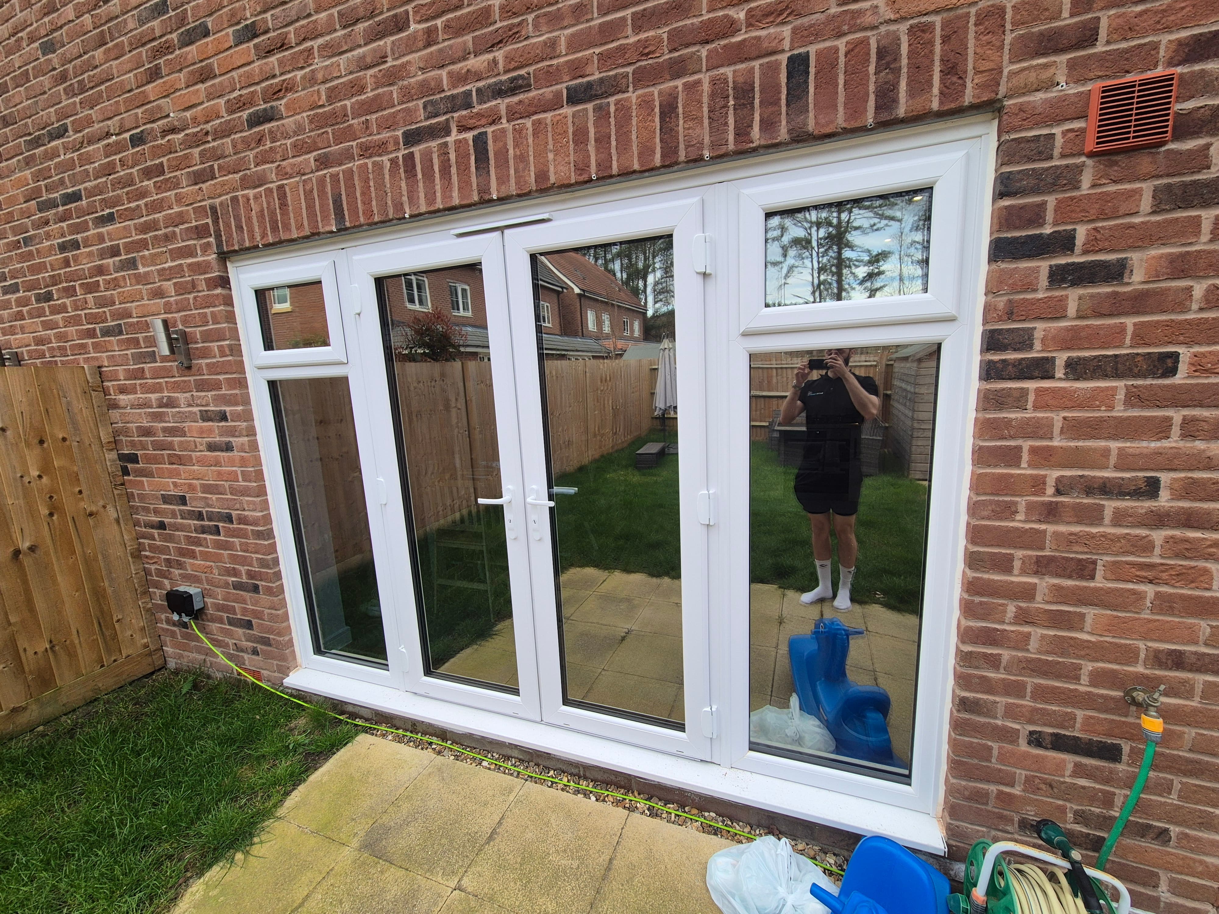 Bi‑fold doors in a Staines‑upon‑Thames property after window film installation, showing a reflective privacy finish that blocks UV rays and reduces heat.